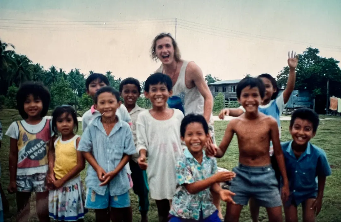 Sean laughing with a group of children on one of his journeys