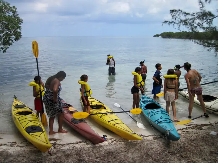 Kayaks lined up in the shallow water
