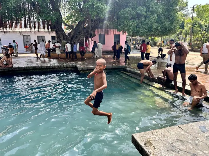 A student leaping into a temple pool