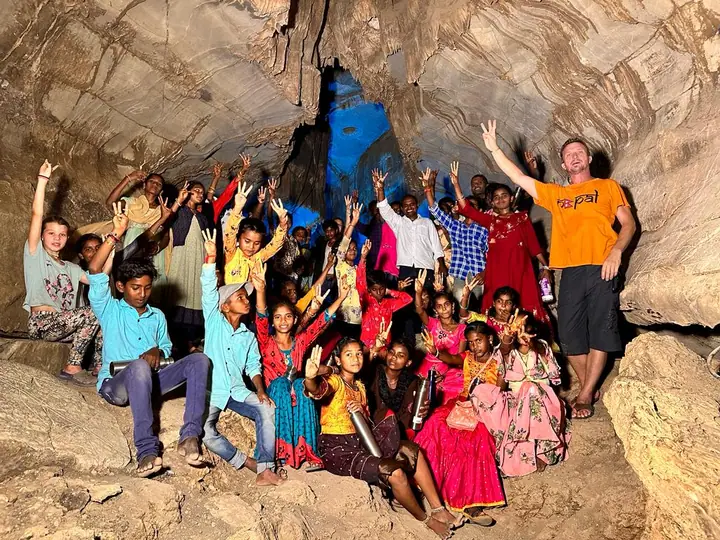 Students cheering together inside a cave