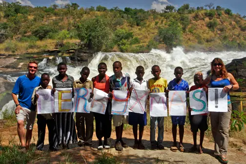 Students holding up letters that spell Merry Xmas in front of the falls