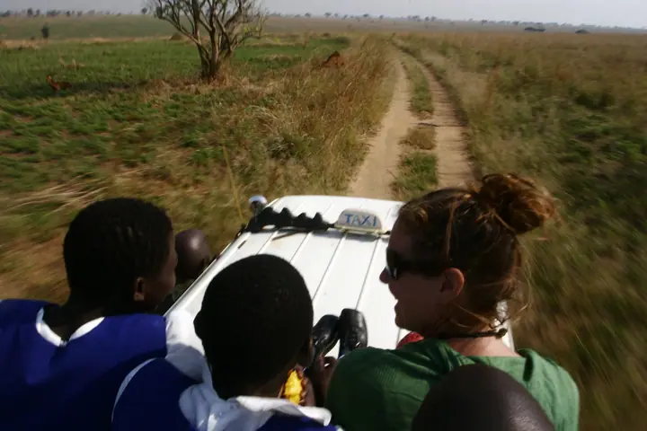Students and a volunteer looking out over the park from the van