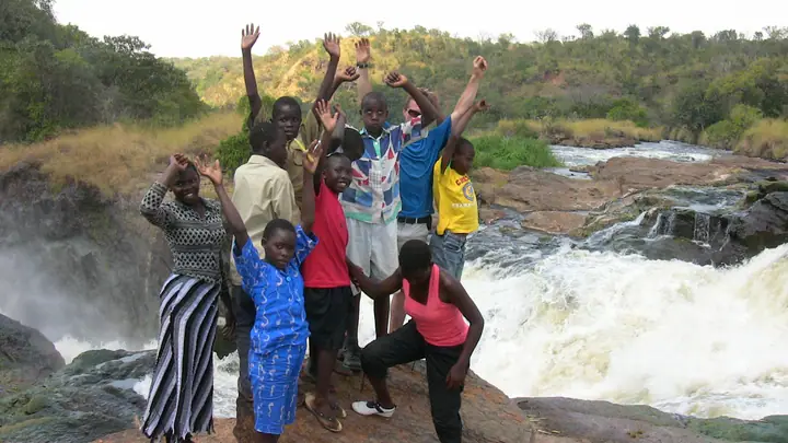 Students cheering with their arms up beside the rapids