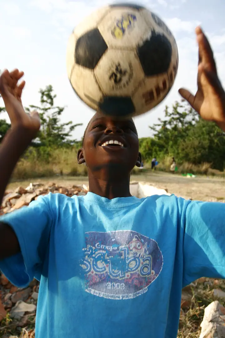 A student balancing a soccer ball on his head